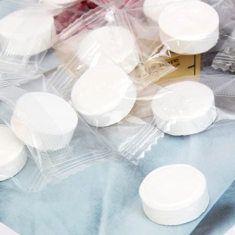 Disposable fiber non-woven compressed white cotton towels, candy individually packaged portable cleansing face cloths.
