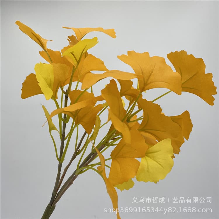 Artificial ginkgo leaves, fake tree branches, yellow leaves, plastic flowers, artificial plants, greenery, indoor landscaping.