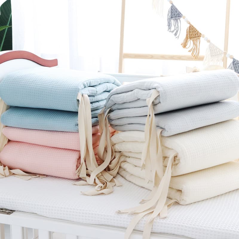 Baby crib bumper set made of one-piece waffle gauze, pure cotton, removable and washable, designed to prevent bumps and falls in newborns.