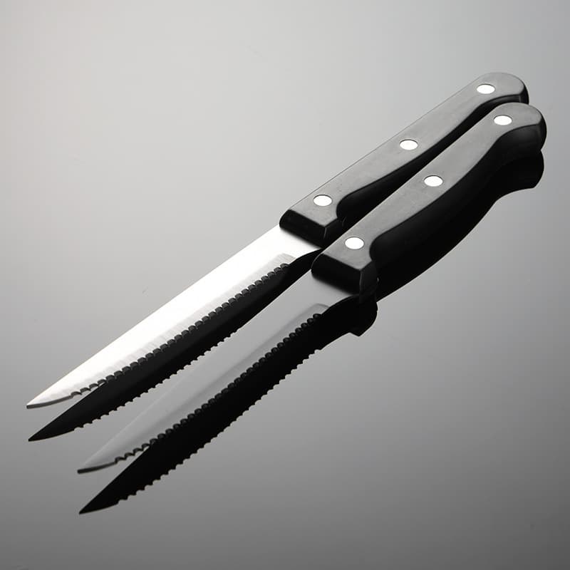 Black 4.5-inch serrated steak knife, 420 stainless steel, with black rivet-studded plastic handle and titanium plating.