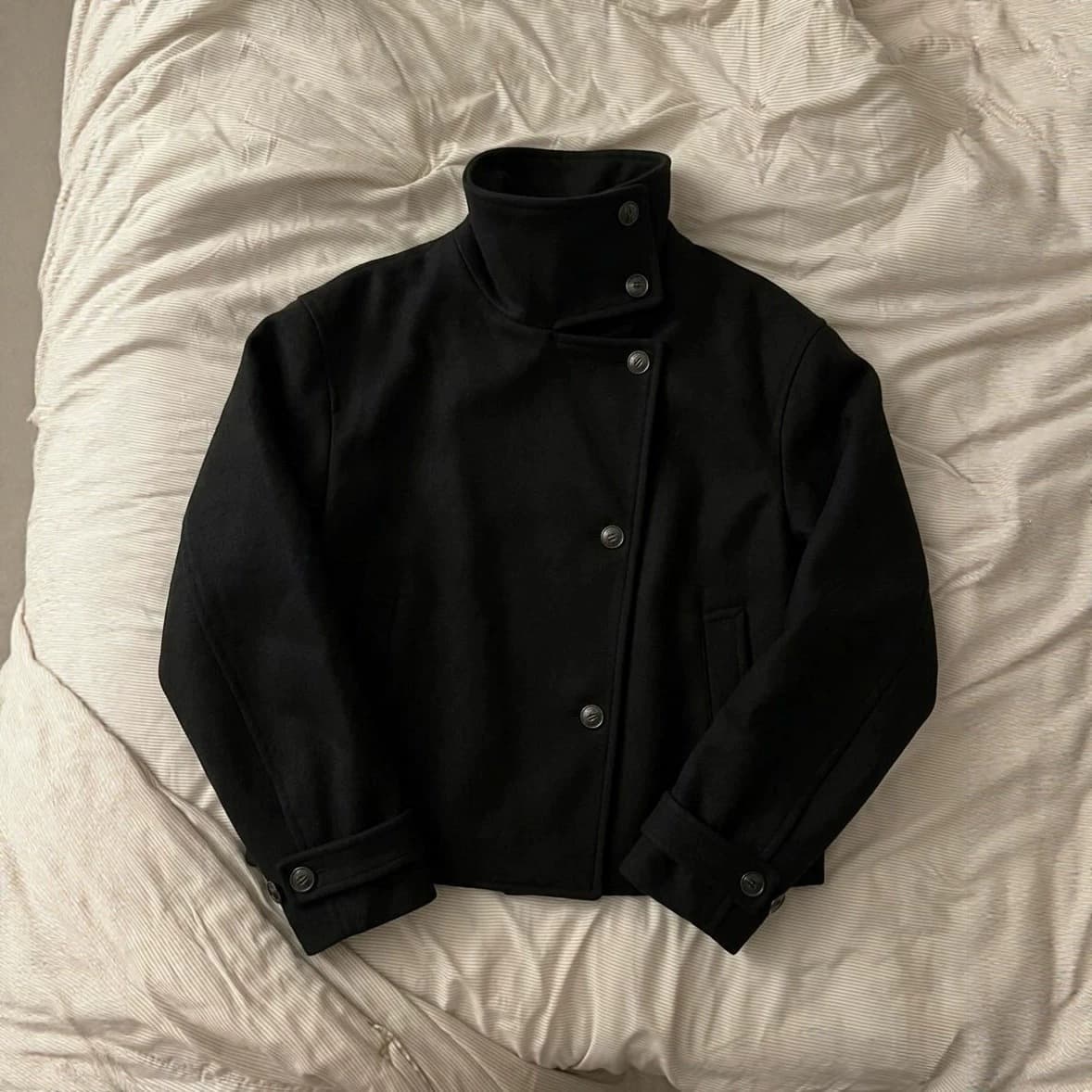 Minimalist High-End Black Short Wool Jacket with High Stand Collar, Diagonal Button Closure, Folded Cuffs, Structured Silhouette Coat Supply