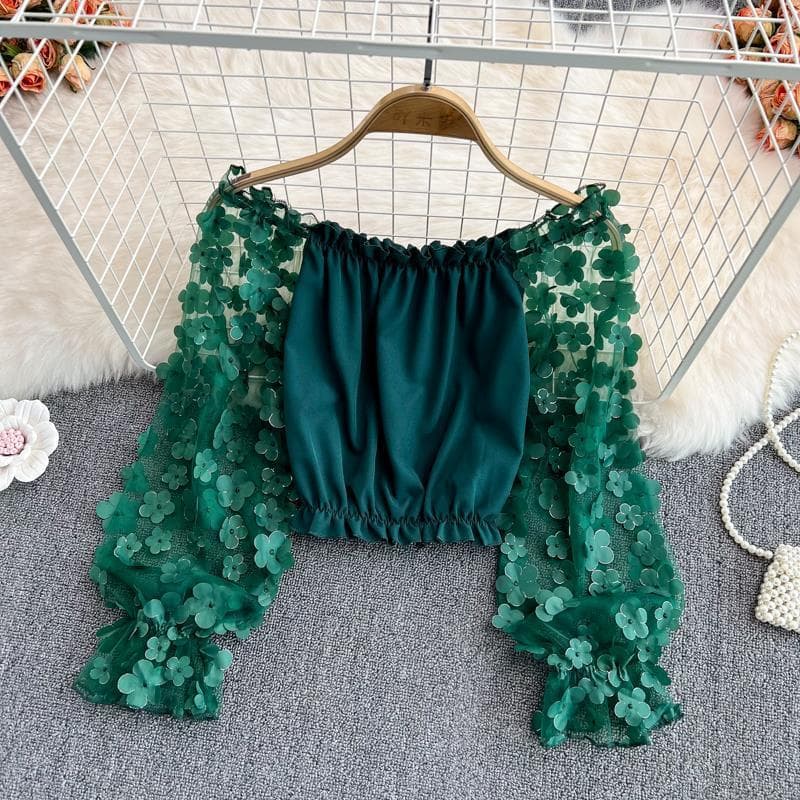 Off-the-shoulder chiffon blouse with 3D floral sheer mesh paneling, loose fit, fitted waist, stylish short shoulder top for summer.