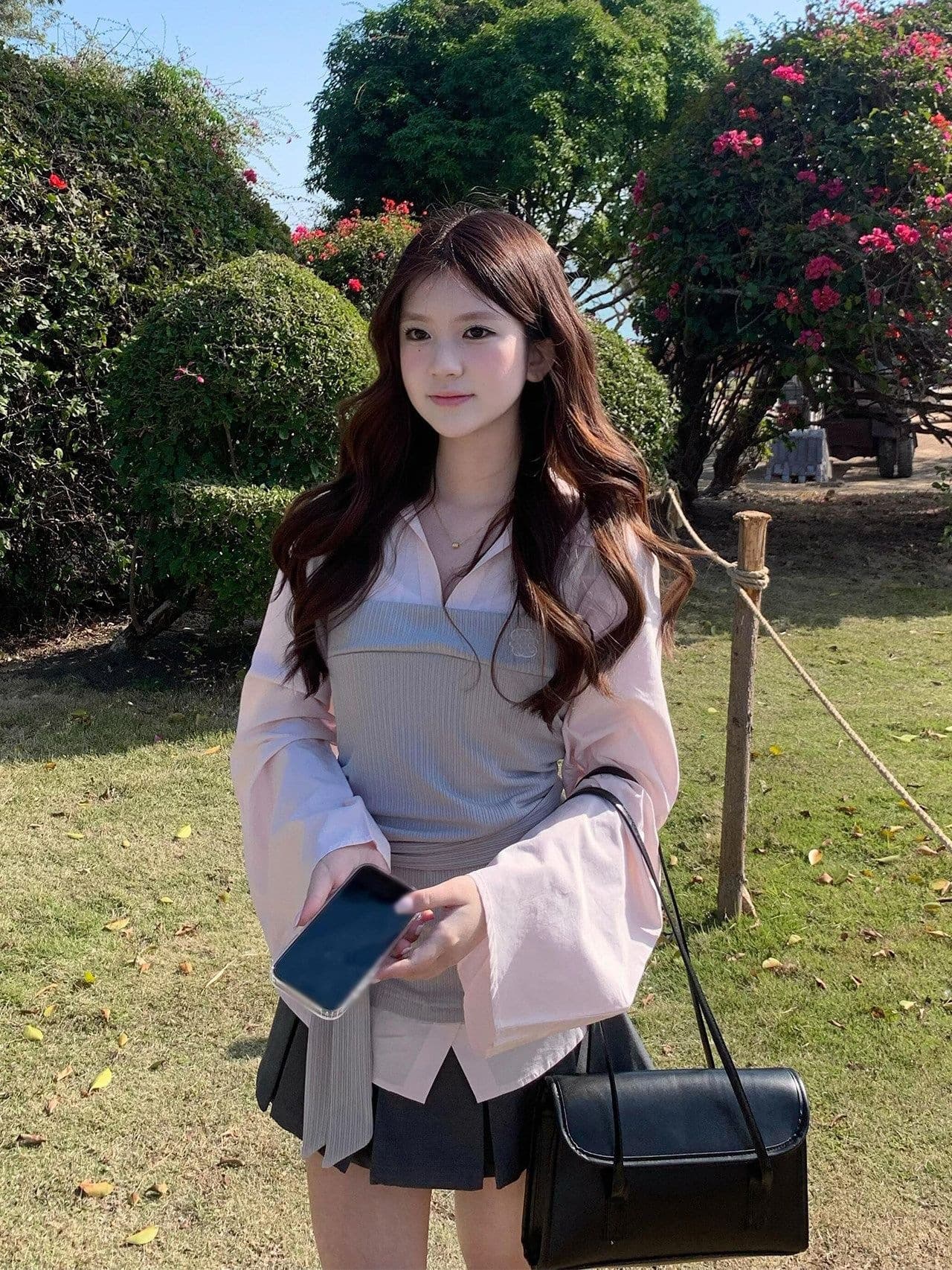 Early spring Korean girls wear a complete set of designer pink long-sleeved fake two-piece shirts and pleated short skirts.