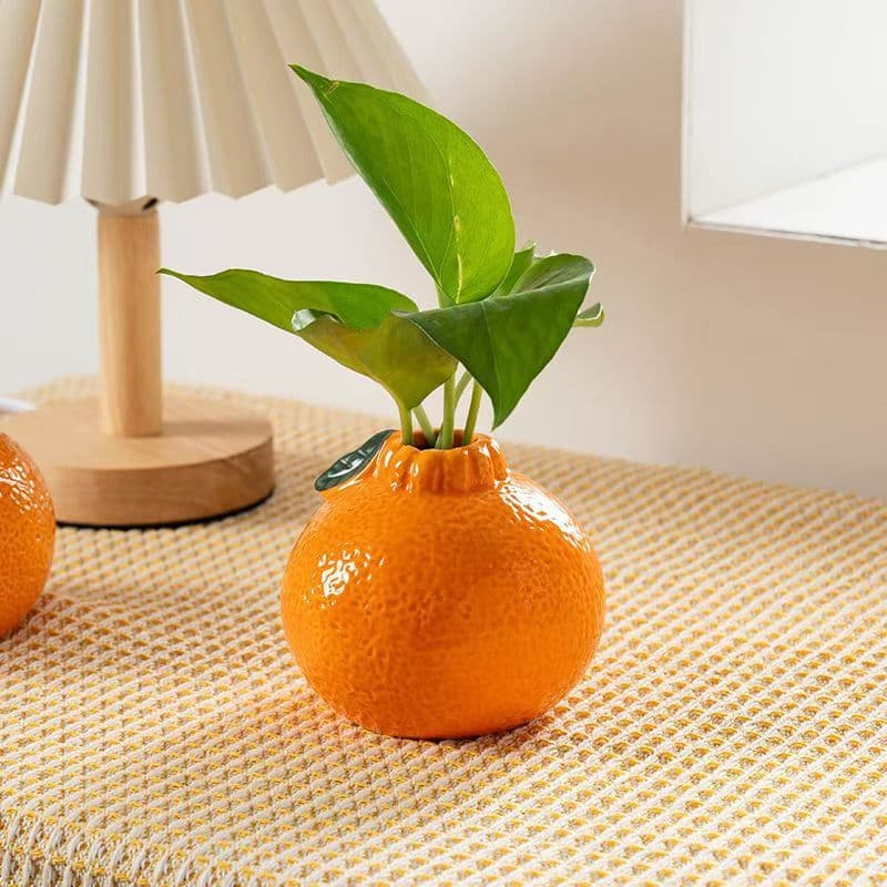 Creative and trendy ceramic orange vase for hydroponic pothos cultivation - a desktop/office decorative piece.