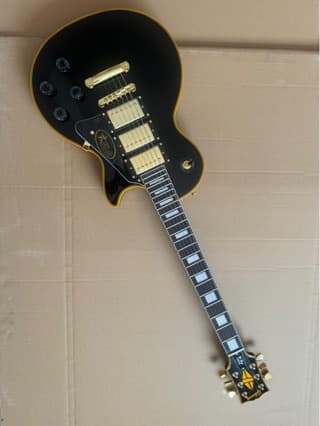 Black Electric Guitar with Yellow Binding, Yellow Logo, and Three Pickups