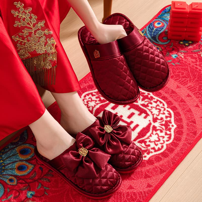 A pair of festive red wedding cotton slippers for newlywed couples, bride and groom, as dowry or autumn wedding footwear.