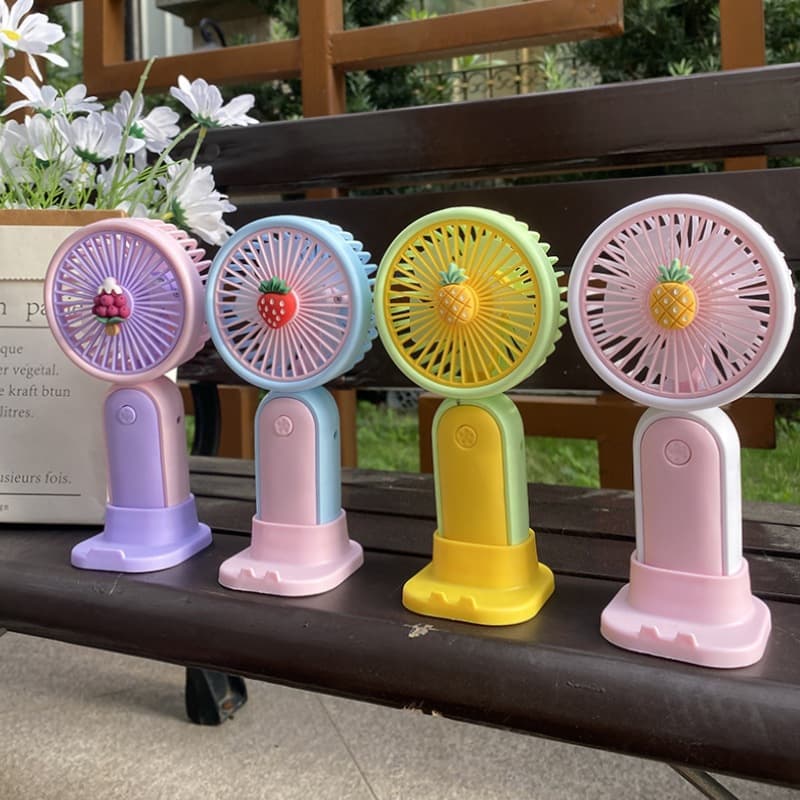Miniature and creative phone stand with USB rechargeable portable handheld desktop fan for students.
