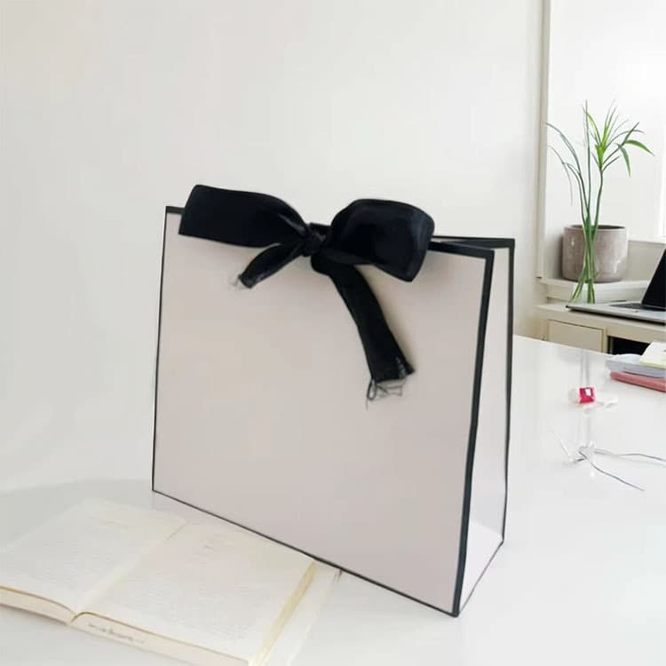 Simple black and white handheld paper bag, bow decorated gift bag, souvenir clothing shopping bag, logo printable