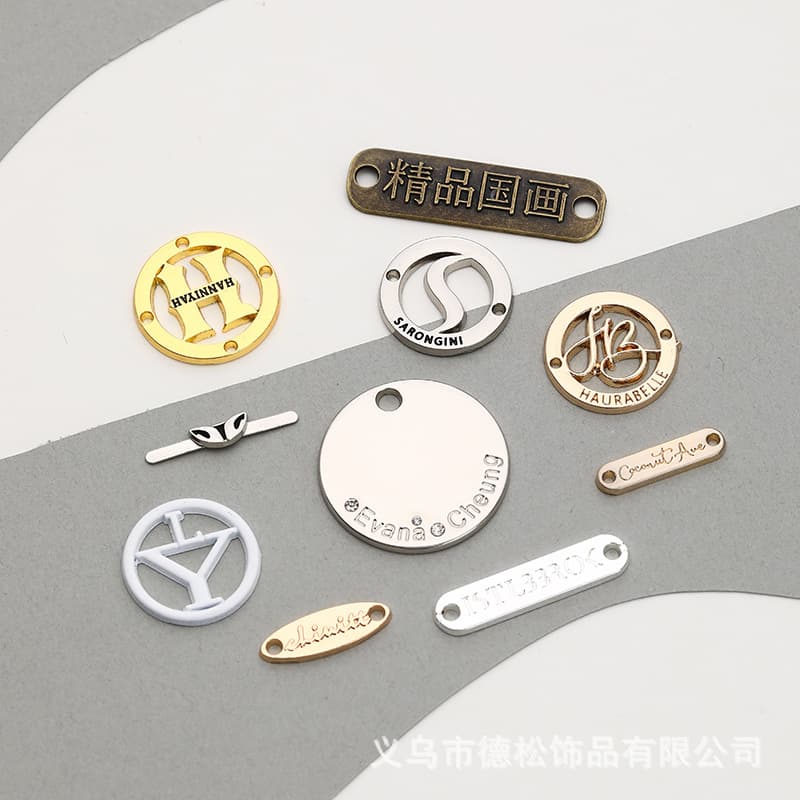 Yiwu manufactures metal nameplates for clothing, including die-cast round hand-sewn sweatshirt accessories, logo painted metal tags.