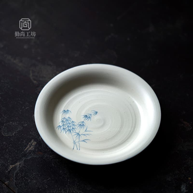 A solitary teapot stand with a painted blue bamboo design, a ceramic lidded bowl base, a tea set accessory, and a household fruit and tea tray.