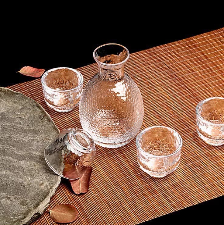 Japanese-style sake sets with transparent gold-rimmed glasses and warmers for spirits and rice wine.