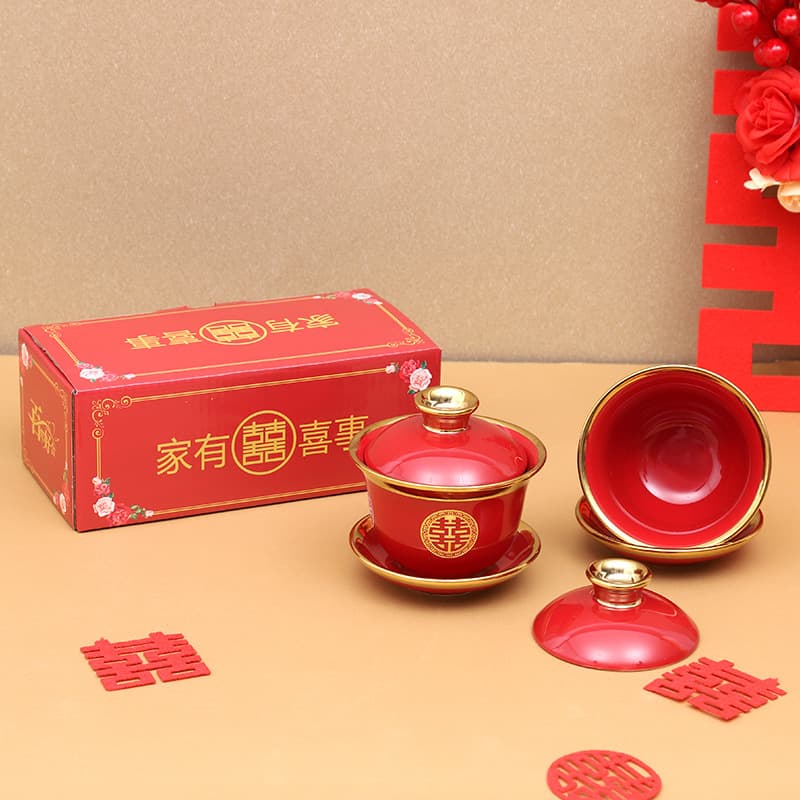 Chinese-style wedding tea set with a pair of ceramic lidded cups for the bride's family, representing union and serving as dowry and celebration gifts.