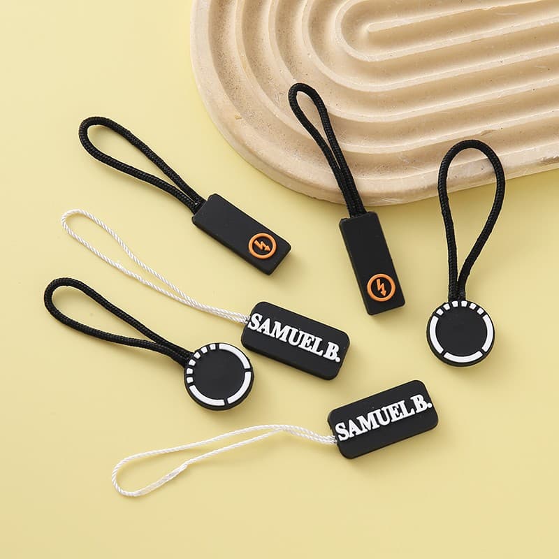 PVC injection molded pull tabs, sportswear rubber clothing, soft plastic custom luggage pull tags, logo zipper pulls, and rubber zipper heads.