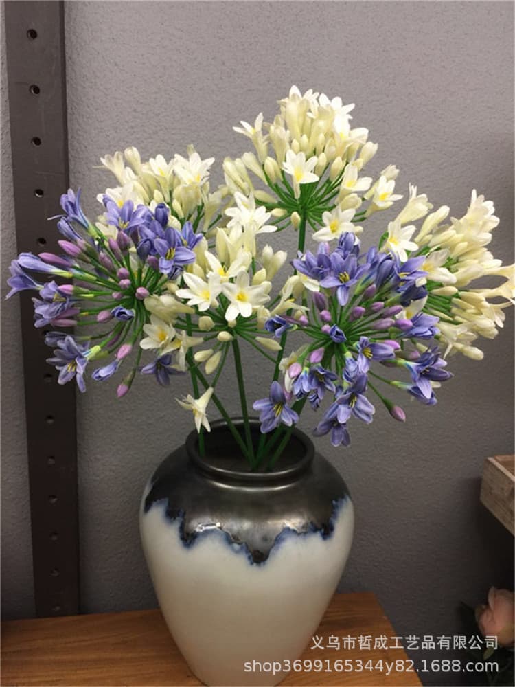 Artificial flower ornaments, including violets, agapanthus bouquets, and African violets, for living room decoration.