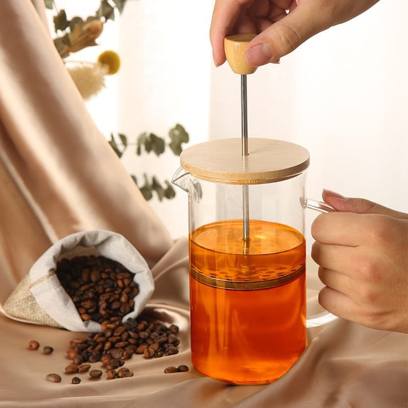 French press made of borosilicate glass, home French filter coffee maker, tea brewing tool with wooden lid.