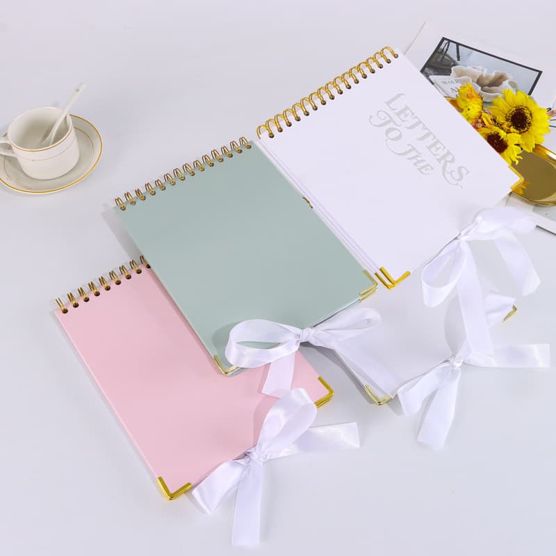 Cross-border blank hardcover bow spiral notebook with gold foil metal corner guards and strap, creative thick notebook