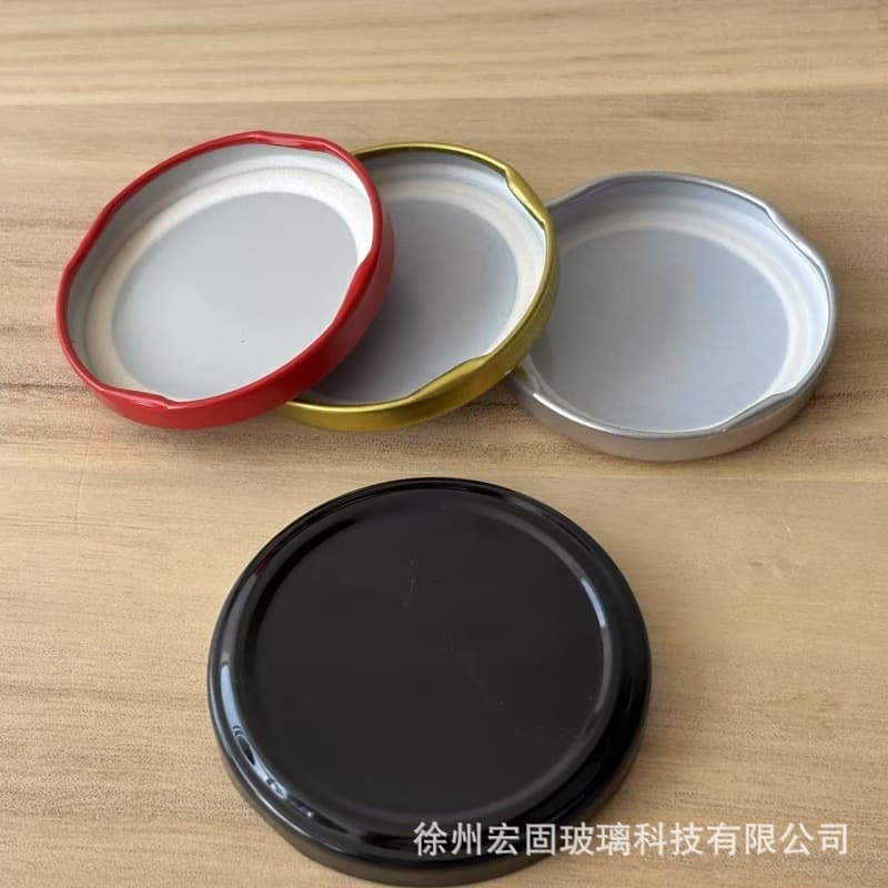 Manufacturer wholesale and custom production of tinplate caps for glass jars, including various models for canned goods, sauces, and peppers.