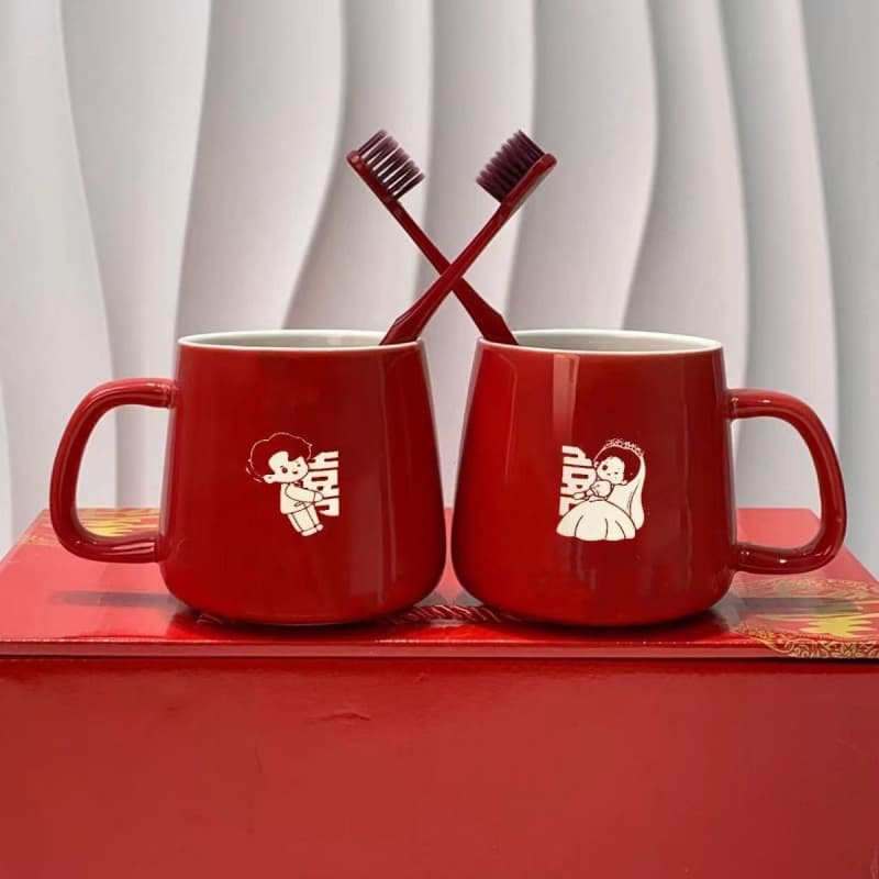 Matchmaker's Recommendation: A pair of red ceramic wedding mugs for rinsing and toiletries, featuring the bride and groom.