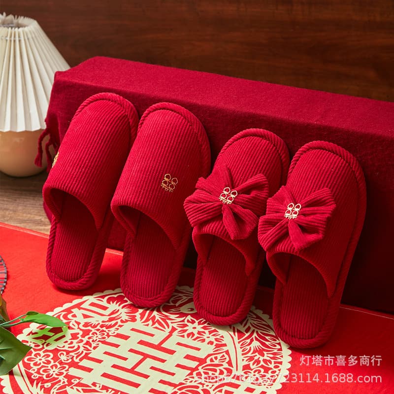 A pair of enclosed warm wedding slippers for couples, suitable for home indoor use by bride and groom in red during autumn and winter.