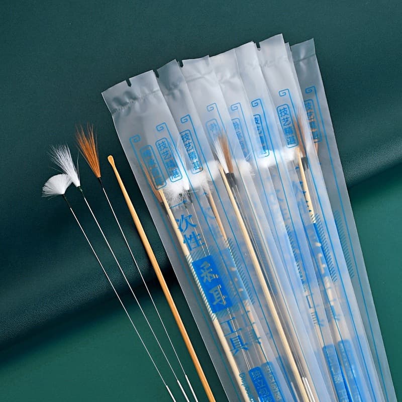 Disposable ear cleaning kit with feather stick, silver needle, chicken feather stick, ear pick brush, and bamboo ear spoon.