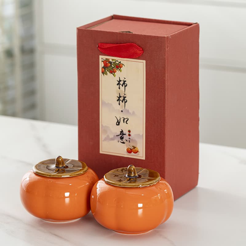 Ceramic persimmon tea canister, symbolizing good fortune, sealed candy storage jar, decorative gift box, suitable for weddings and business openings.