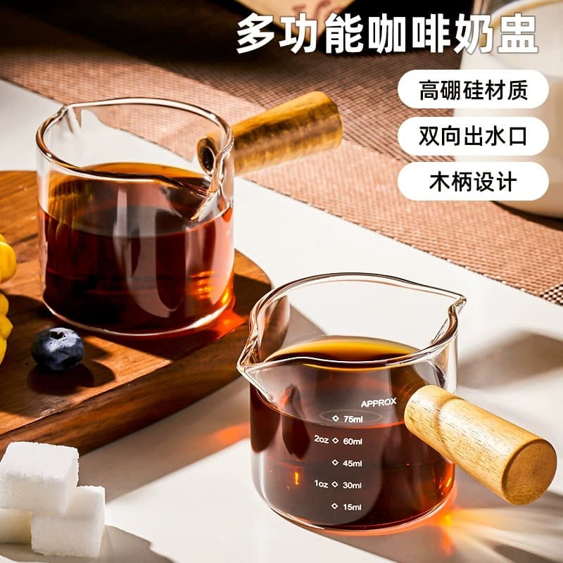 Small borosilicate glass milk jug with double spout and wooden handle; suitable for home use; transparent glass coffee cup with graduations.