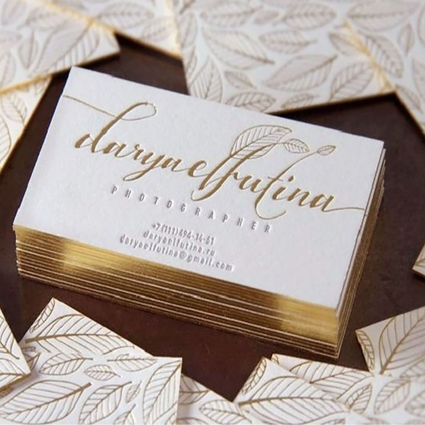 Black cardstock and cotton paper business cards with gold edges, foil stamping, and embossed effects for premium quality