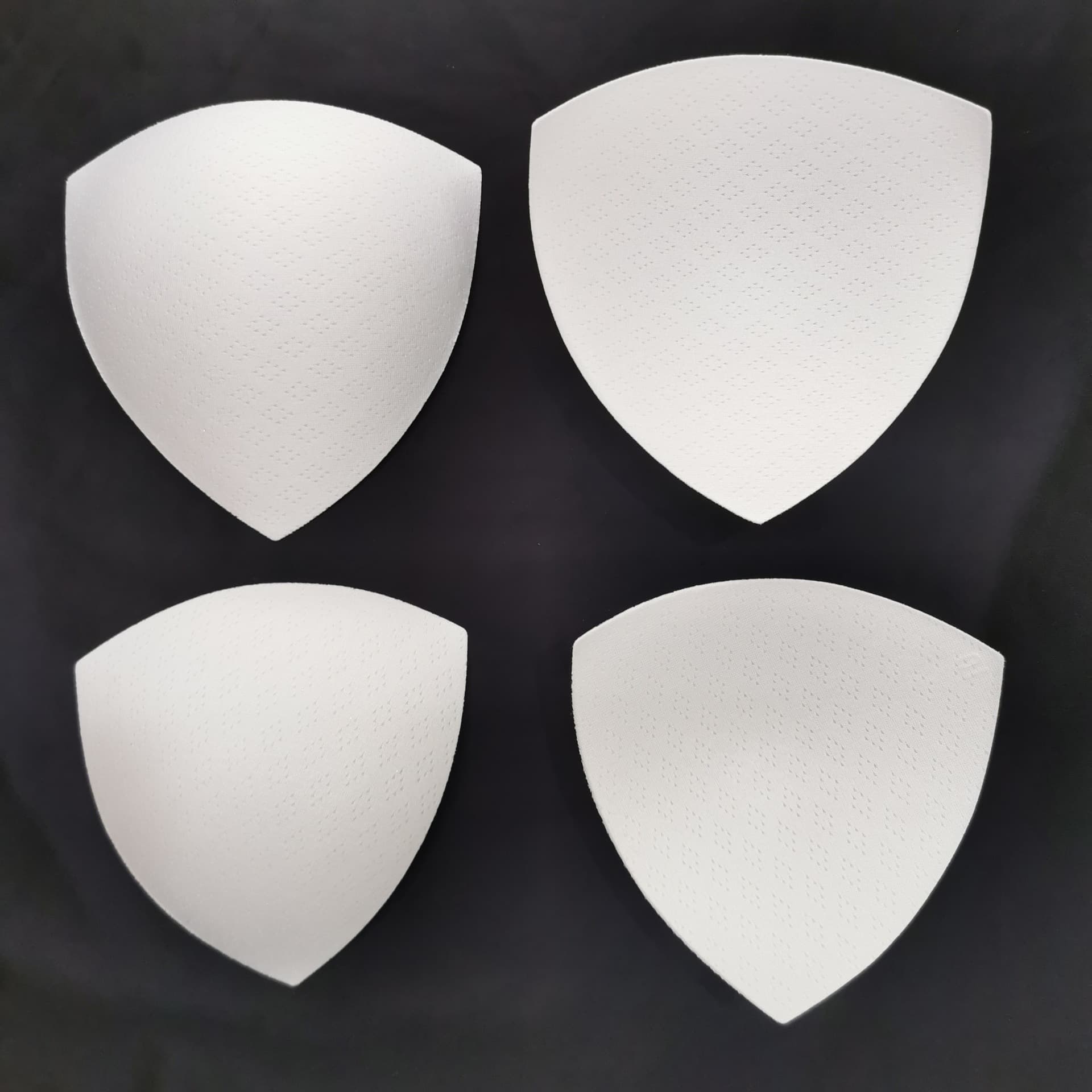 Triangle breast pad sponge inserts for swimwear cups, thin eight-hole breathable sponge pads, high rebound breast pad inserts.