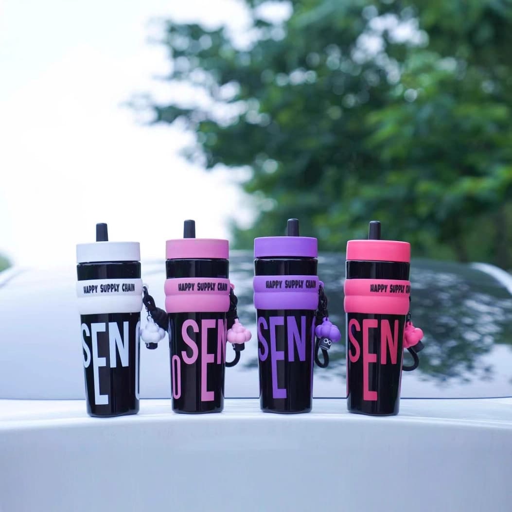 Wholesale of high-temperature resistant, aesthetically creative plastic water cups with straws, featuring stylish letter designs for portable use