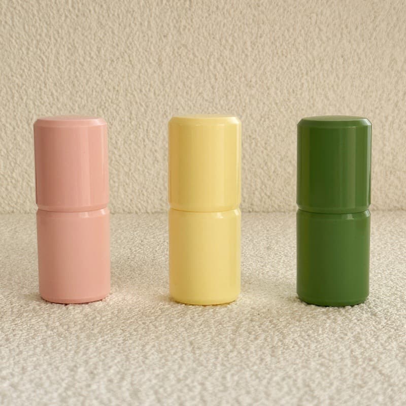 Empty round twist-up blush stick, cream highlighter, and deodorant balm packaging tube