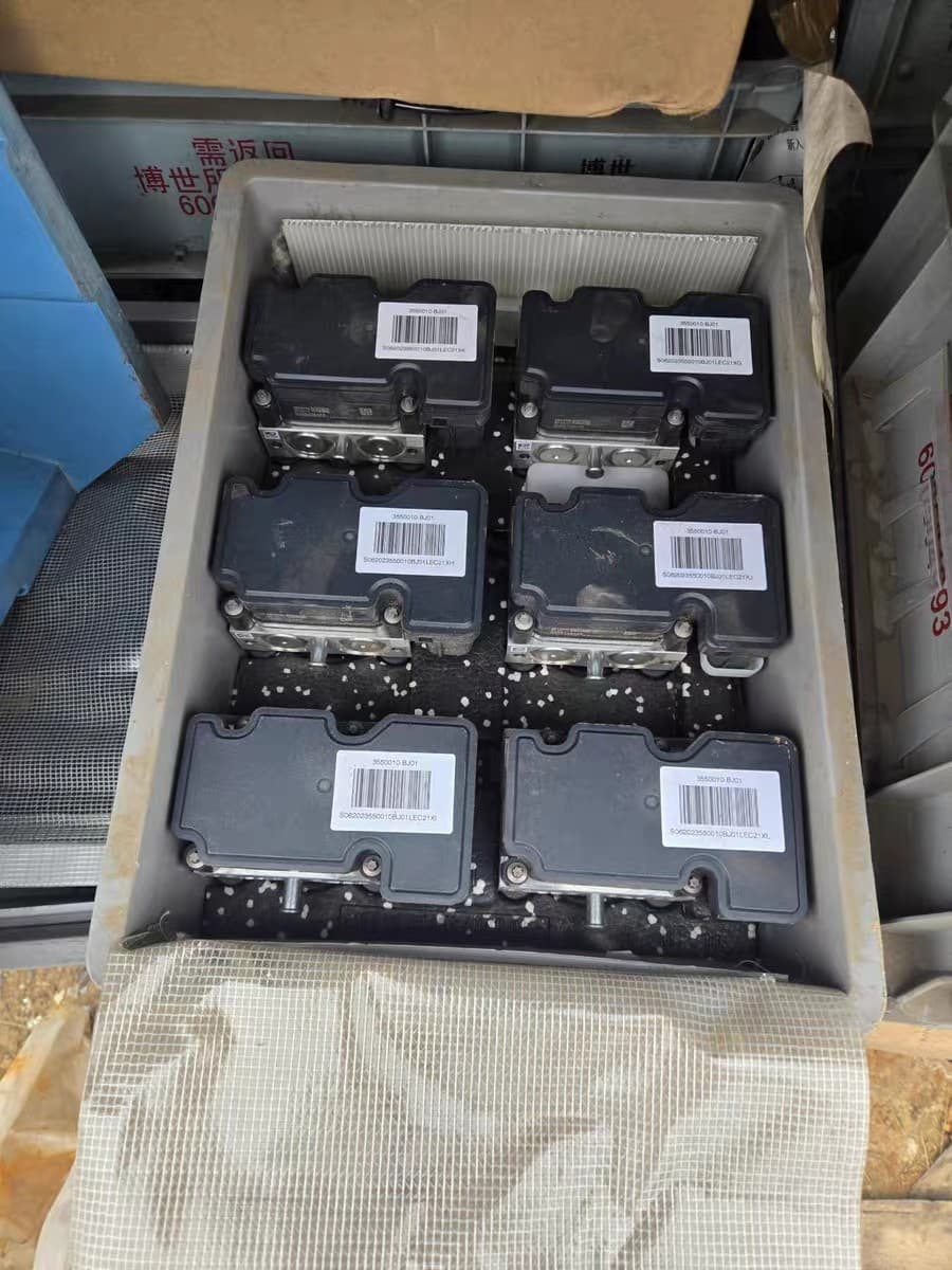 Bulk ABS pumps and electronic parking brakes for cars, packaged for shipment, all covered by warranty as returned factory parts.