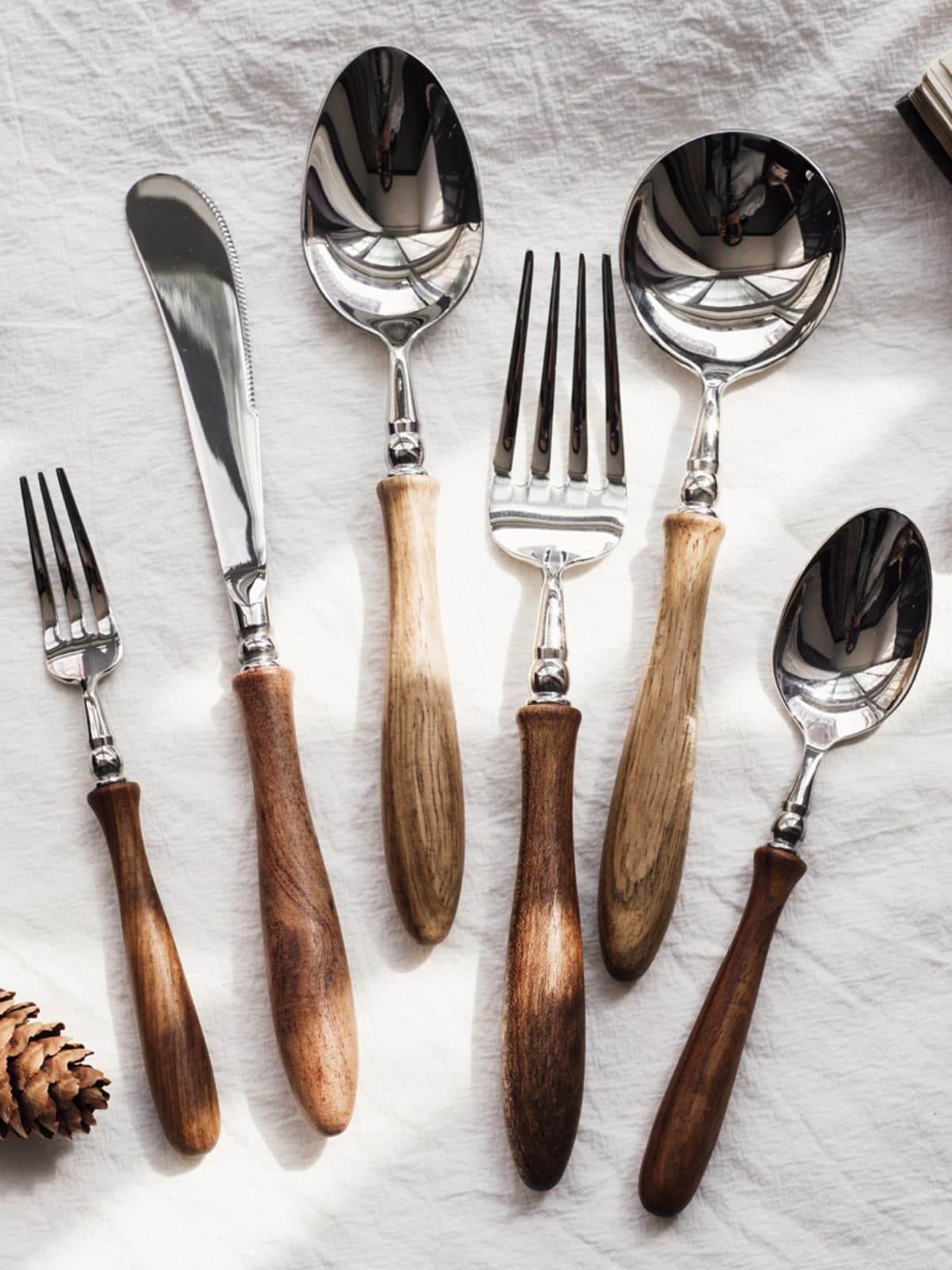 French-style vintage-style cutlery with wooden handles: pasta fork, main course dessert spoon, steak spoon.