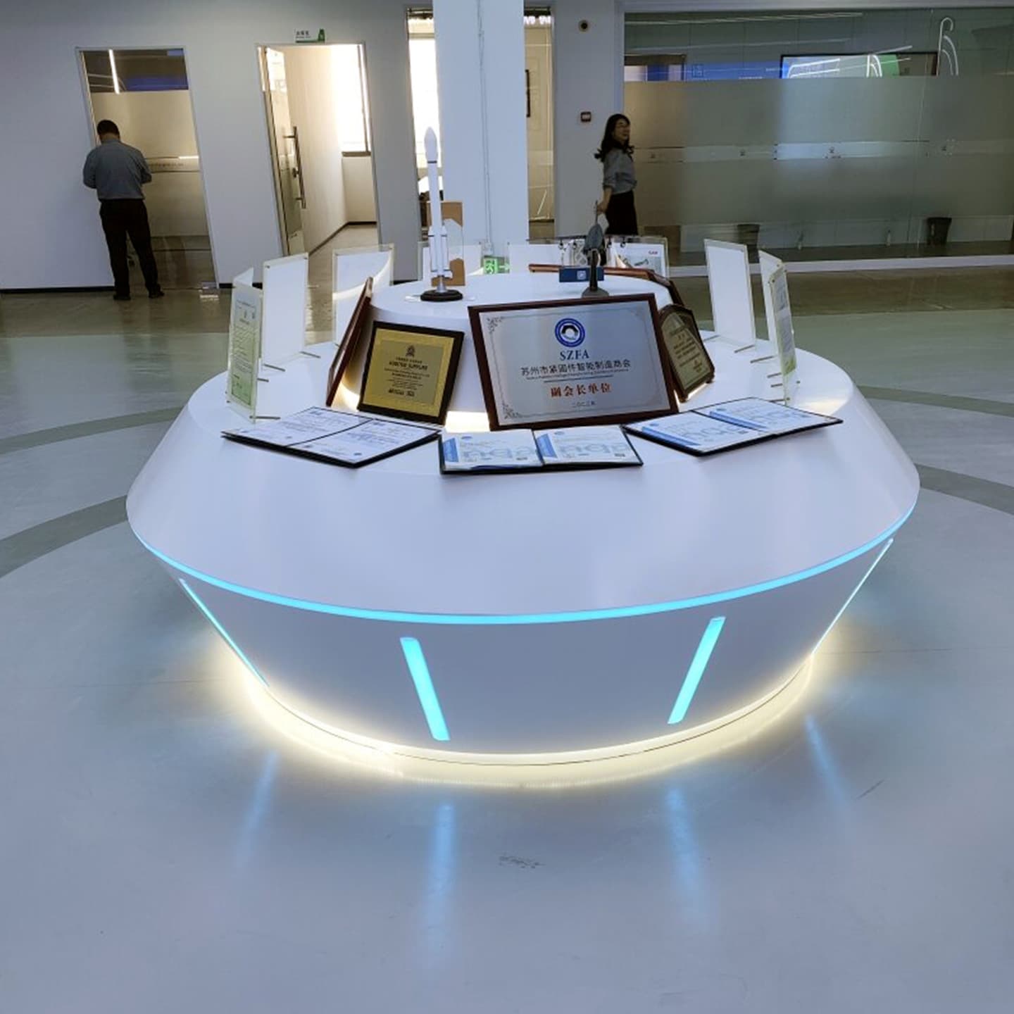 Custom Painted Oval Display Stand Showcase with Cool Tech-Style Drone Display Cabinet and Illuminated Central Island Experience Table