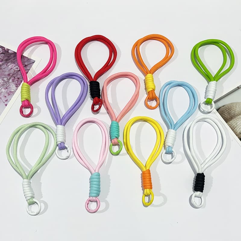 Short phone lanyard with color-blocking, knotting, woven design, plush keychain, and 15cm anti-loss strap.