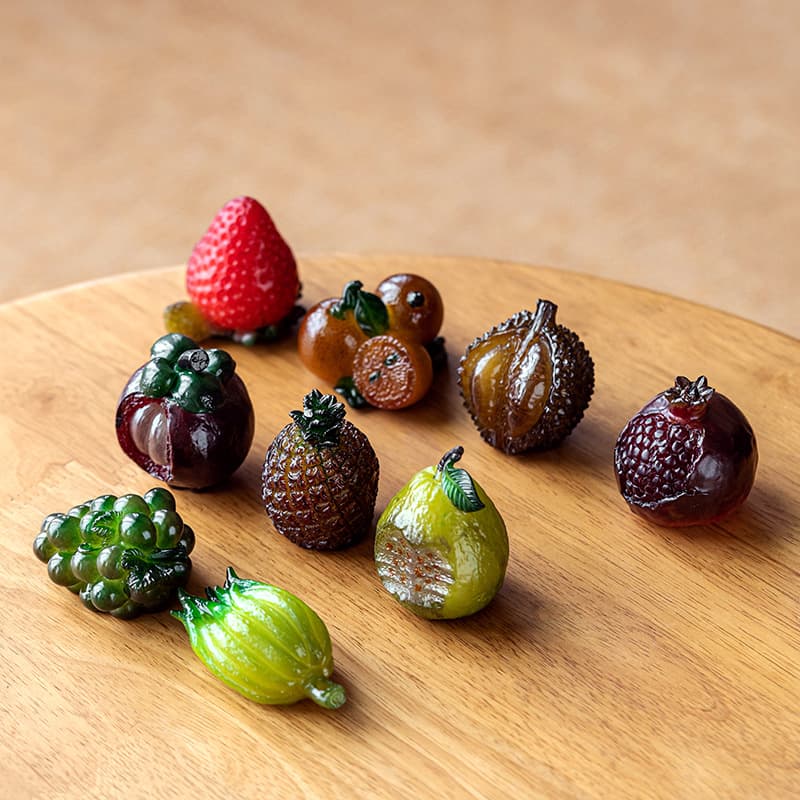 Color-changing fruit tea pets including lychee, bayberry, pomegranate, and realistic miniature strawberry resin 3D micro fruit decorations.