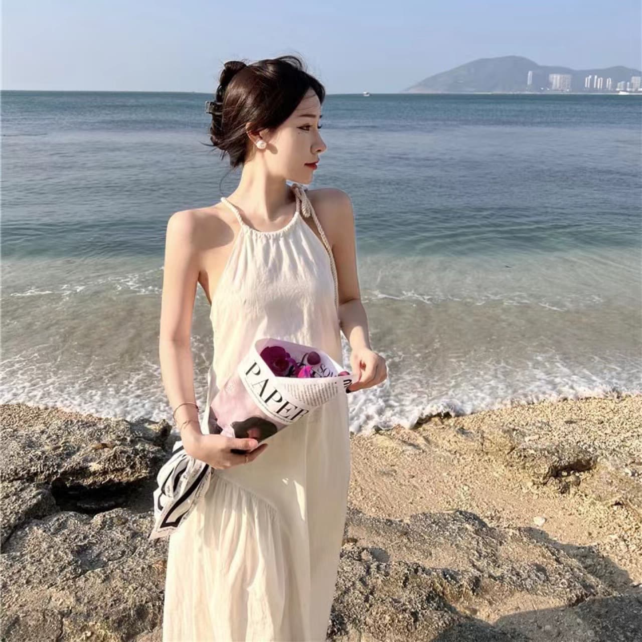 Adjustable halter neck dress with French-style cutouts in a solid white color, perfect for a summery and stylish beach trip.