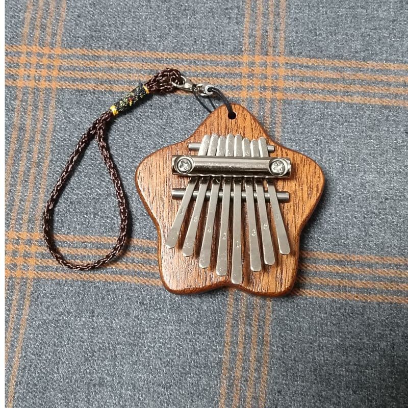 Mini 8-note kalimba thumb piano, palm-sized, mini, portable, cute, trendy, hollowed-out thumb piano with 8 notes.