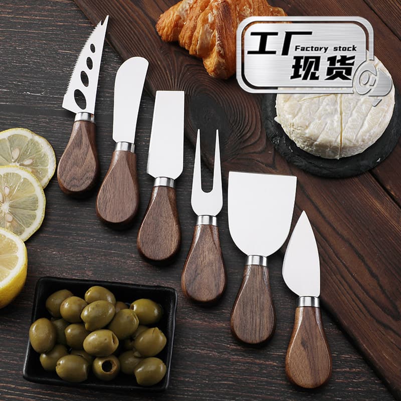 Black pizza cutter with walnut handle, cheese knife, stainless steel cheese tool, butter spatula, fork, kitchen cutlery.