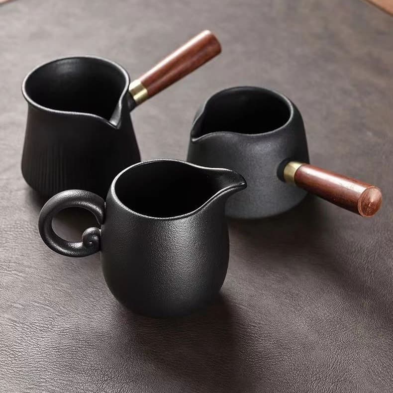 Black ceramic and solid wood side-handled fairness cup, single tea dispenser, retro Chinese style tea set accessories for home use.